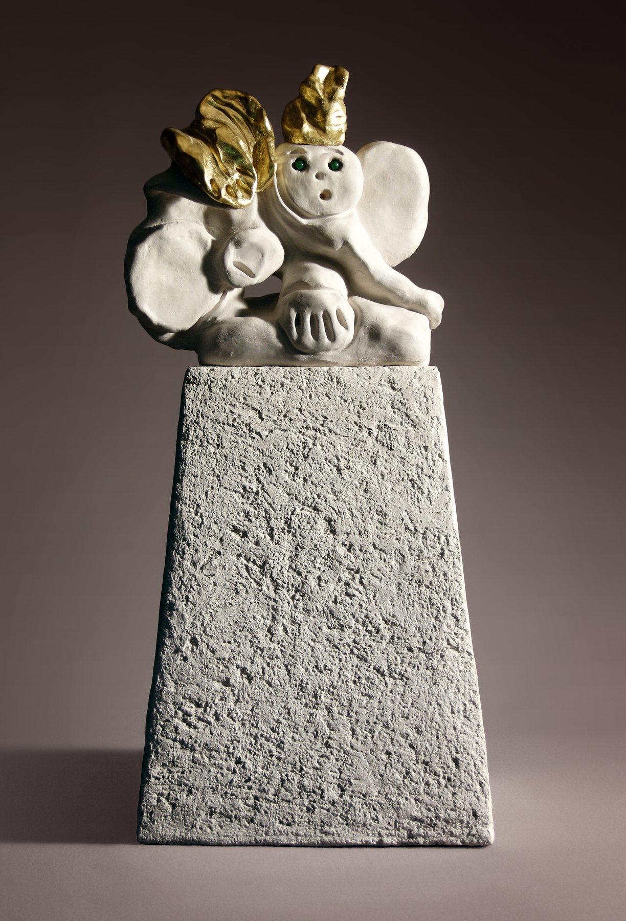 White stoneware elephant with gold details, seated on a tall plinth